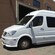The side of a shiny Mercedes minibus with tinted windows